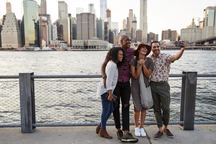 Charter Bus to New York City - Leprechaun Lines - Group Of Friends Posing For Selfie In Front Of Manhattan Skyline